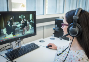 Film Studies student watching a French film on a computer with headphones